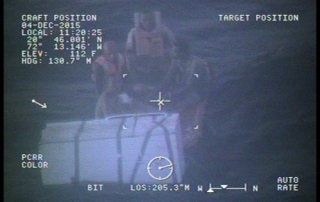 A Coast Guard MH-60 Jayhawk helicopter crew from Air Station Clearwater, Fla., rescues four Haitian men 50 nautical miles southeast of Great Inagua, Bahamas, Dec. 4, 2015. The men were found floating in a life raft after their vessel sank. U.S. Coast Guard photo.